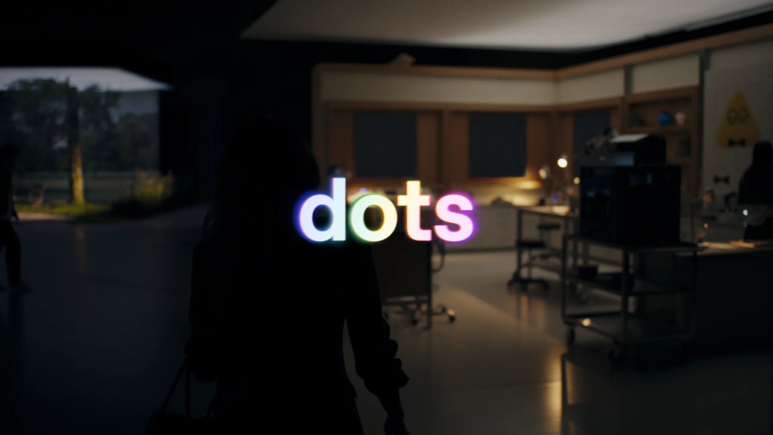 Still from the OpenAI Dots launch film with the glowing dots logo over a dimly lit office