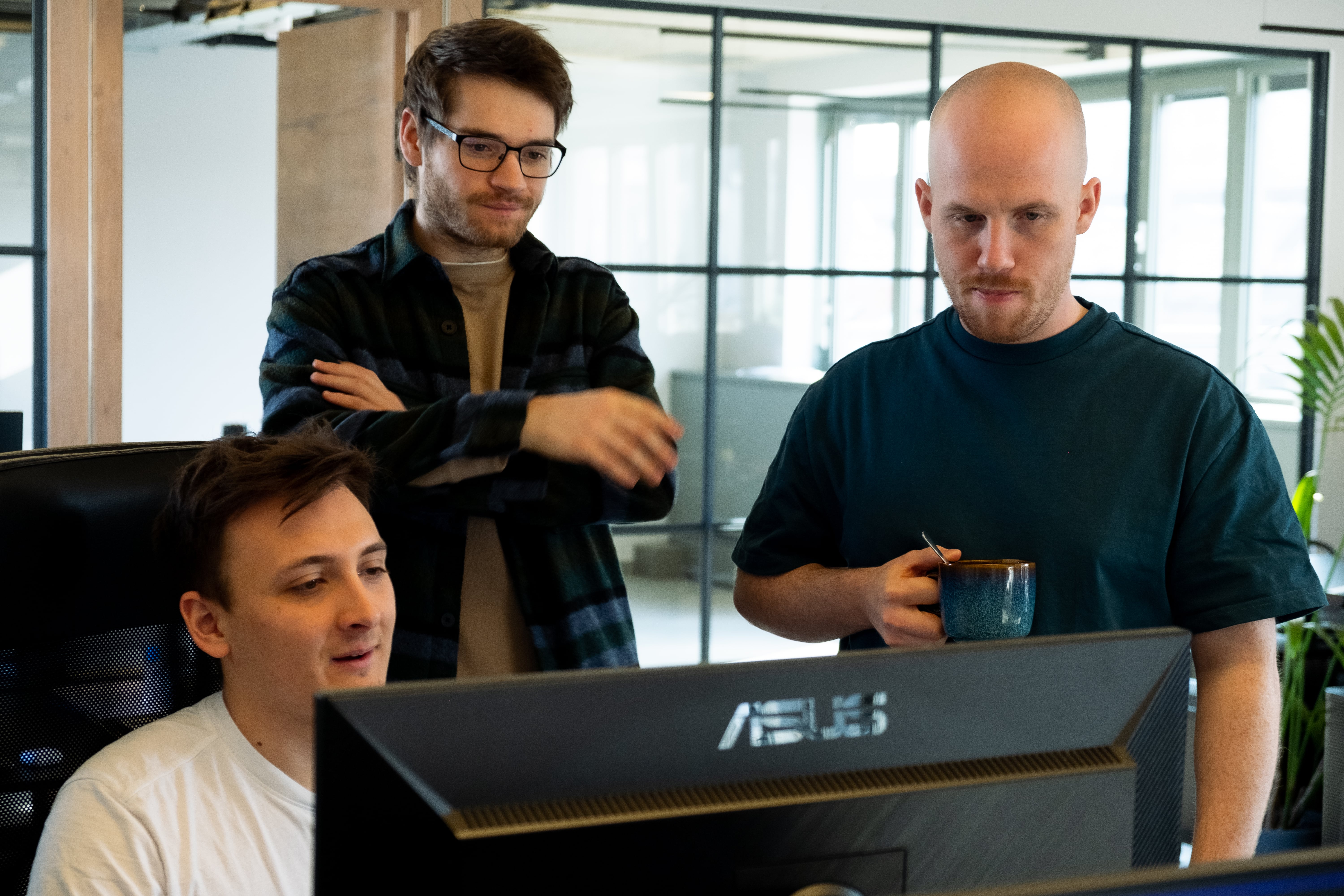 Dotbite Developers looking at a screen Dotbite Developers looking at a screen