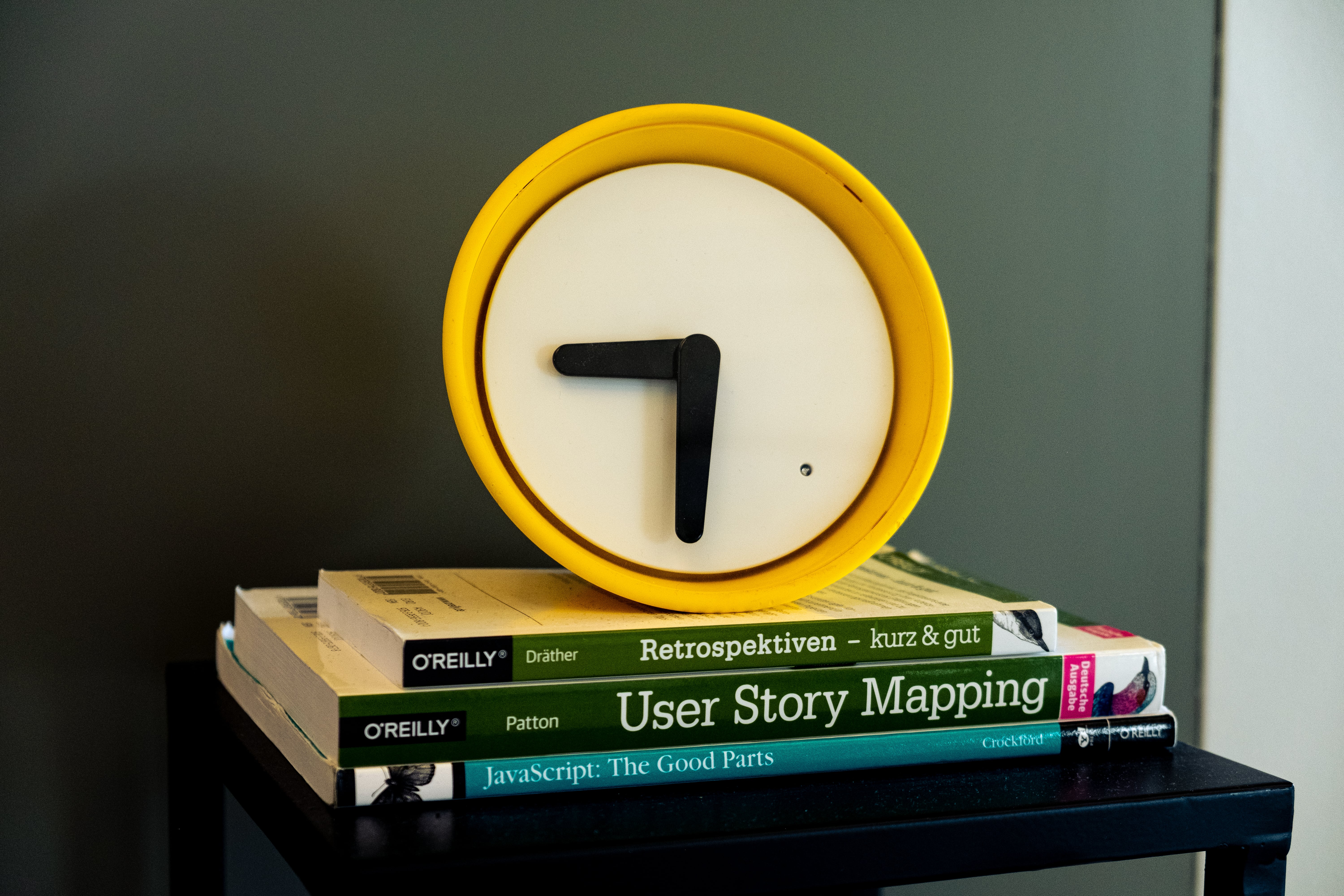 Small yellow watch sitting on some books as office accessoire Small yellow watch sitting on some books as office accessoire